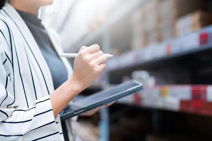 Restoran stok yönetimi için tablet üzerinden dijital stok takibi yapan kişi, envanter kontrolü ve verimlilik
